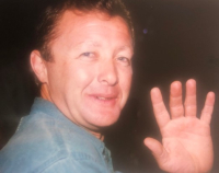 Image of Darren, white male wearing a blue shirt, waving and smiling at the camera